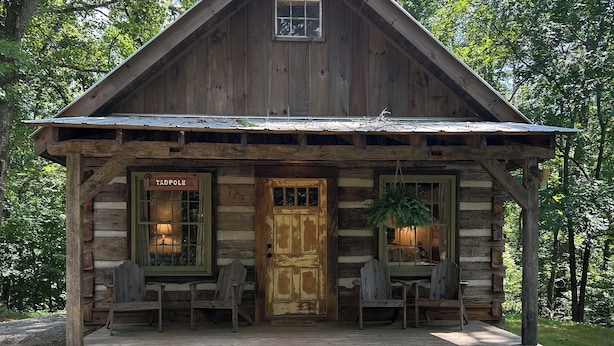Eine rustikale Holzhütte mit Veranda, zwei Fenstern und einer Tür mit der Aufschrift 'Tadpole'.