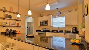 A modern kitchen with a central island, built-in appliances, and pendant lighting.