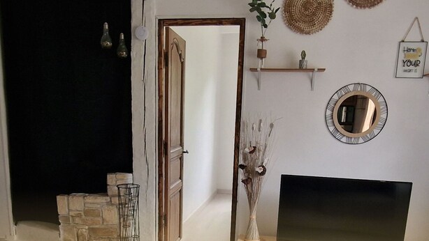 Habitació amb una llar de foc, televisió, mirall i elements decoratius a la paret.
