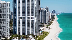 A high-rise hotel with a beach view, multiple floors, and a long beachfront promenade.