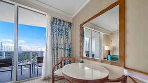 A hotel room with a balcony, a round table, and a large mirror.