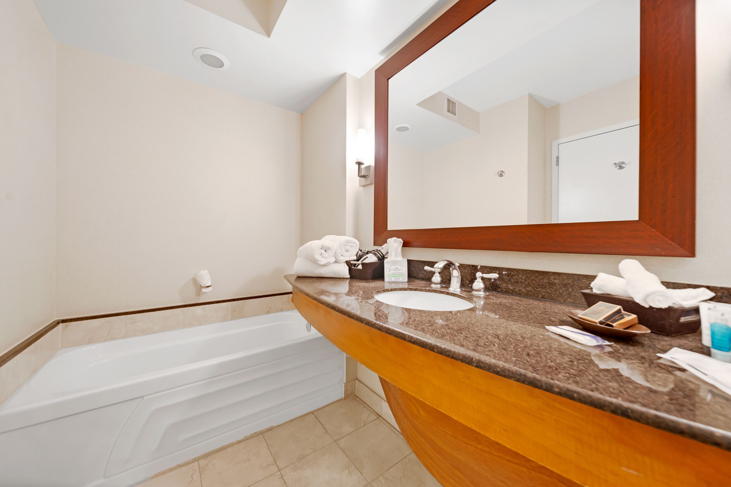 Une salle de bain moderne avec une baignoire, un lavabo et un grand miroir.