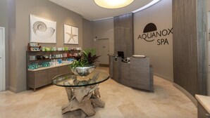 A reception area with a glass table, a plant, and a reception desk.