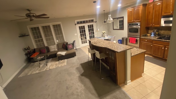 Una cocina amplia con barra, una mesa de comedor y un espacio de estar con sofá y sillones.