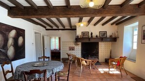A dining area with a round table, chairs, and a fireplace. - CHEZ CAZALETS - SUSMIOU (SUSMIOU)