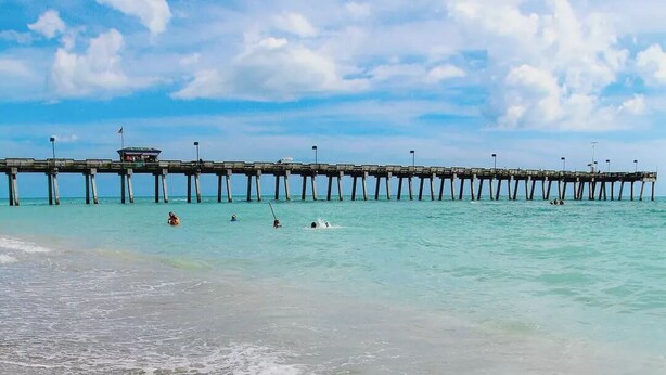 A pier extending into calm turquoise waters with a sandy beach in the foreground. - Venice Escape 6 Minutes to Beach & near YMCA Pool (Venice)