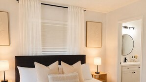 A neatly made bed with a tray of breakfast, a bedside table with a lamp, and a bathroom visible through an open door. - Venice Escape 6 Minutes to Beach & near YMCA Pool (Venice)