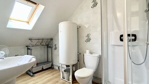 A bathroom with a toilet, a shower, a sink, and a window. - Studio for 2 in the city center (Le Crotoy)