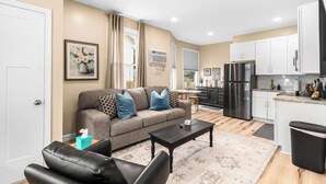 Un appartement moderne comprenant un salon, une cuisine et un coin repas.