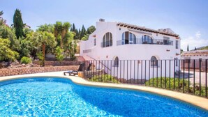 Une piscine avec un bâtiment blanc en arrière-plan.