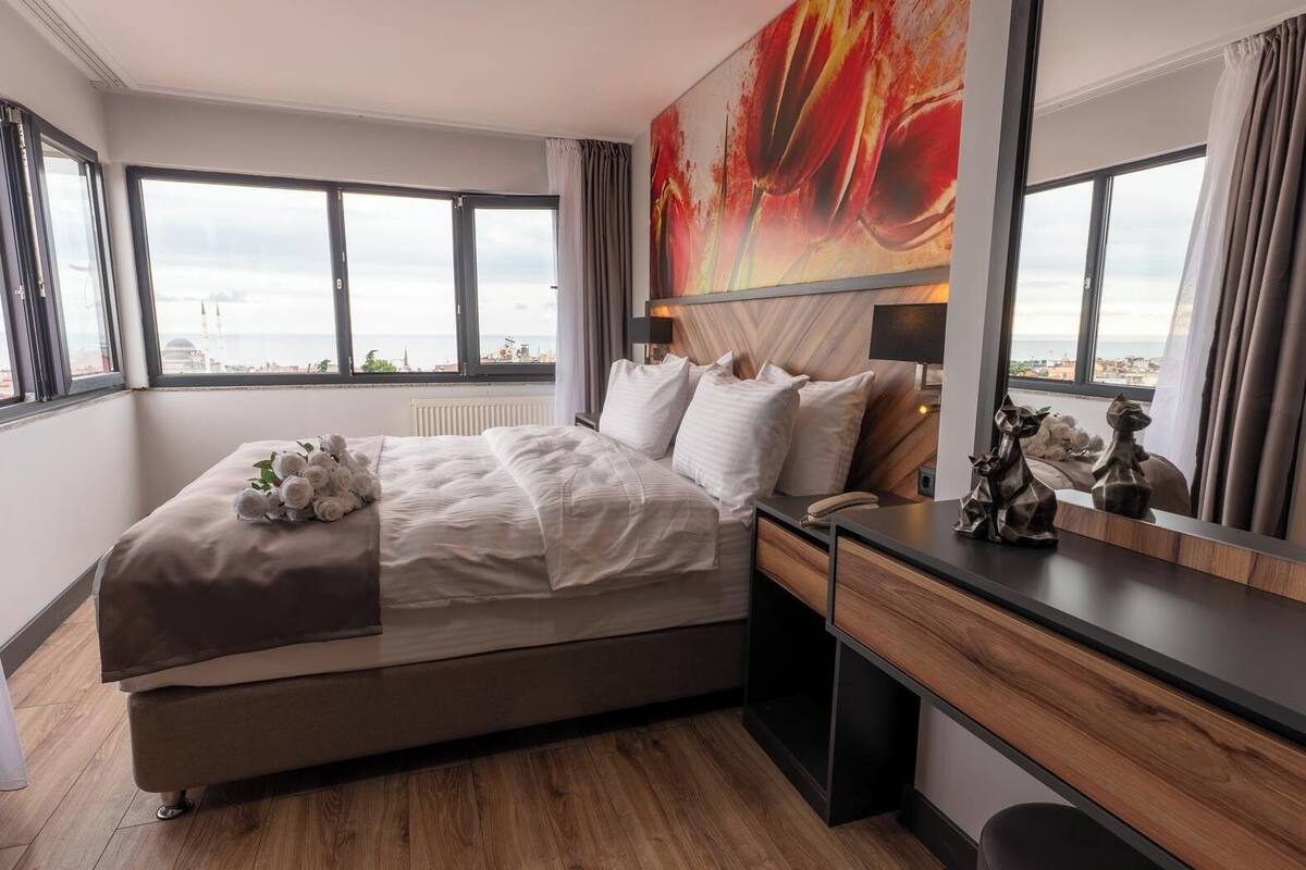 Ett modernt hotellrum med en stor säng, ett skrivbord och utsikt över havet.