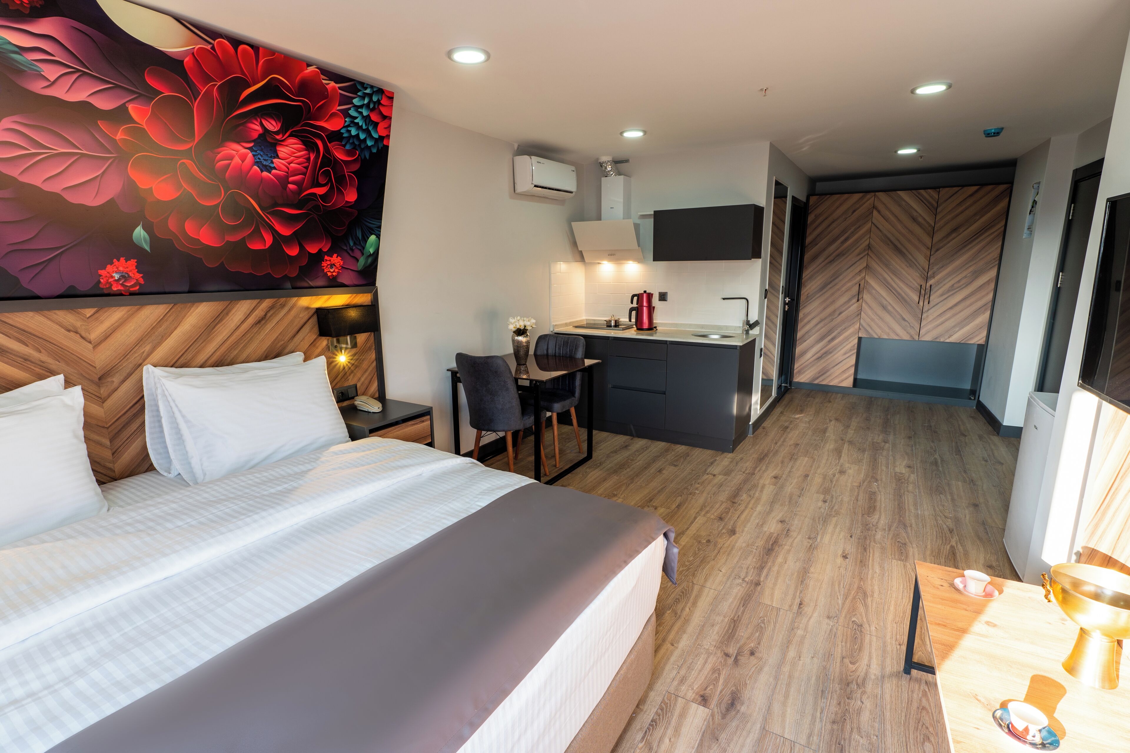 Une chambre d’hôtel moderne équipée d’un grand lit, d’un bureau, d’une chaise et d’une kitchenette.