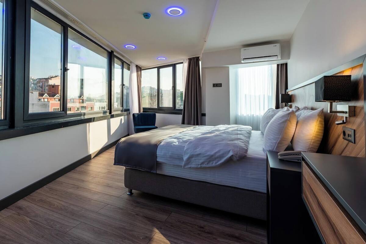 Ett modernt hotellrum med en stor säng, ett skrivbord och en TV.