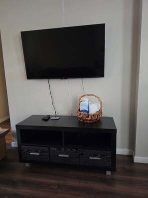 A black entertainment center with a flat-screen TV mounted above it. - A perfectly quiet spot away from home! It's nestled just outside of Maplewood. (Irvington)