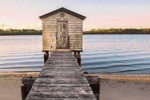 Access the wheelhouse from the weathered pier, situated at the end of a sandy beach.