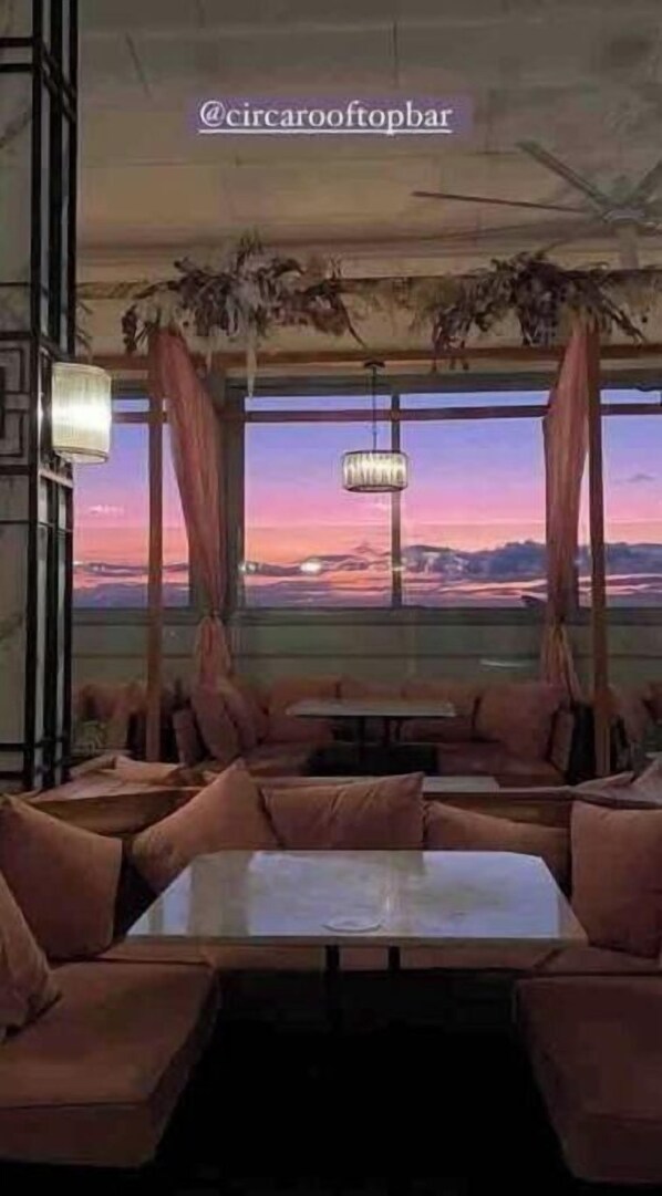 Relax in a cozy seating area with cushioned benches and tables, offering a view of the surrounding landscape.
