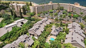 Un hôtel doté d’un bâtiment aux lignes courbes, d’une piscine et offrant une vue sur l’océan.