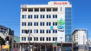 A multi-story building with a prominent 'SHARP' sign at the top. - Liberty Apartment Hotel (Wellington)