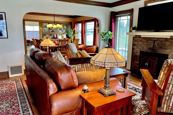 Spacious living area with original arches, crown moldings & wood framed windows