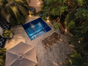 An outdoor swimming pool surrounded by tropical plants and wooden furniture. - 6 Bedroom Charming Colonial House With Pool (Santa Marta)