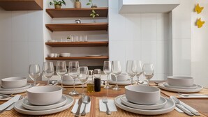 A dining table set with white plates, bowls, and wine glasses, with a bottle of olive oil and salt shakers. - 6 Bedroom Charming Colonial House With Pool (Santa Marta)
