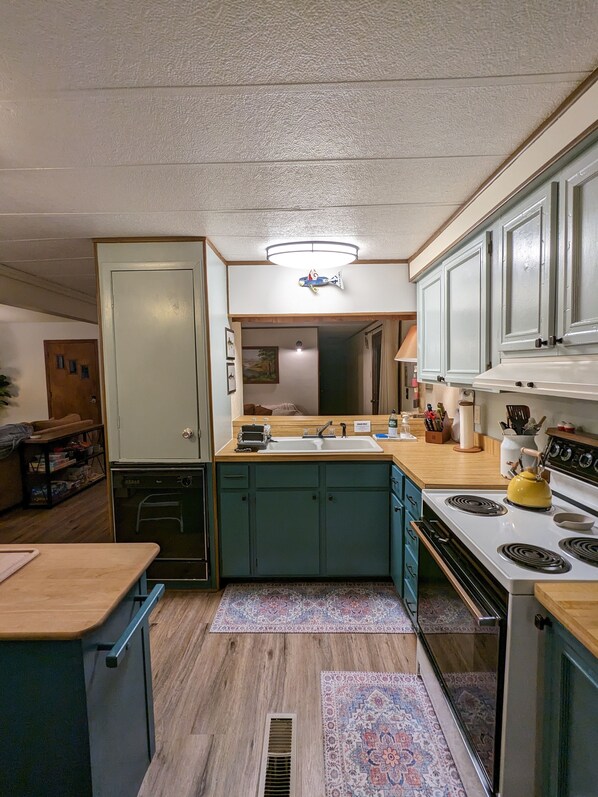 A compact kitchen with a central island, a built-in oven, and a stove.