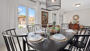 A dining room with a dark wooden table set for six, surrounded by black chairs. - Beautiful 3BR2BA, Amazing Location w/ Private Pool (Noord)