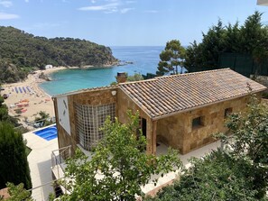Overlooking the beach, this property features a swimming pool and lush greenery.