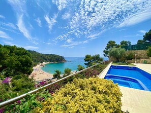 Una piscina con vista a una playa y al mar.