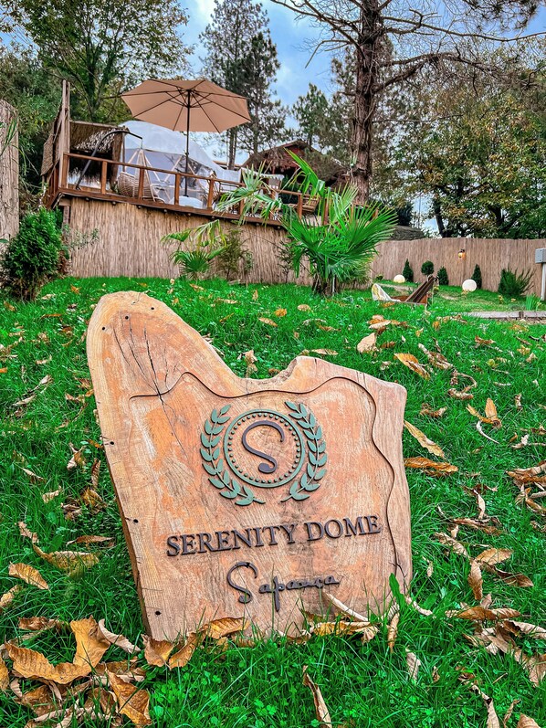 Een houten bord met de tekst 'Serenity Dome' en 'Sahara', wat de naam van de locatie aangeeft.