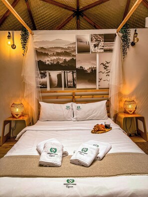 Ein Bett mit weißen Laken, zwei Handtücher und ein Tablett mit Speisen.