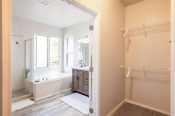 A bathroom with a bathtub, a shower, a vanity with a mirror, and a towel rack. - The Park House, Cozy Family-Friendly Retreat (Brighton)