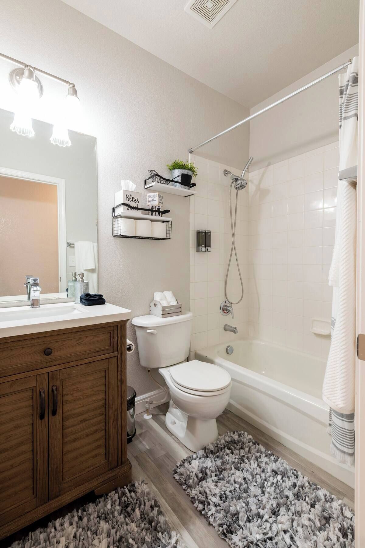 Un baño moderno con tocador de madera, inodoro, bañera y ducha.