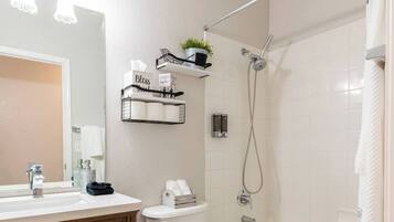 Un baño moderno con tocador de madera, inodoro, bañera y ducha.