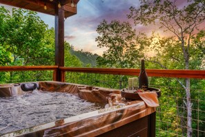 Un bain à remous avec une terrasse en bois et une vue sur une végétation luxuriante.