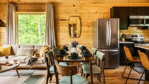 Un intérieur de chalet chaleureux comprenant un coin repas, une cuisine et un espace de vie.