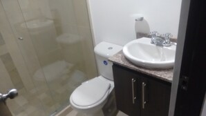 A bathroom with a toilet, a sink, and a shower area. - Great Location: Apartment Nearby Itagui Metro Station (Sabaneta)
