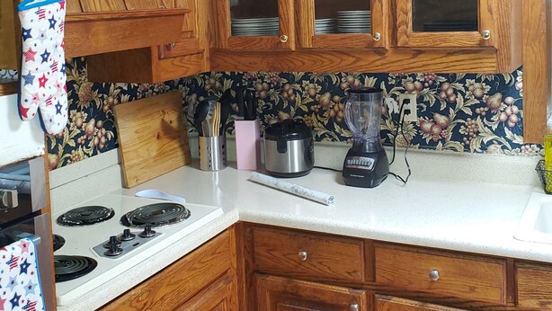 A kitchen with wooden cabinets, a stove, and various appliances.