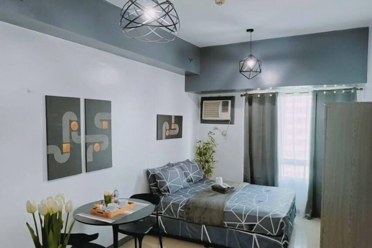 Ein modernes Schlafzimmer mit einem Bett, einem kleinen Tisch mit Blumen und zwei Wandleuchten.