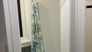 Une salle de bain avec un rideau de douche orné d’un motif floral.