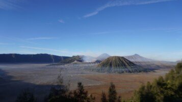 Vista panorámica de un paisaje volcánico con una montaña destacada en el centro.