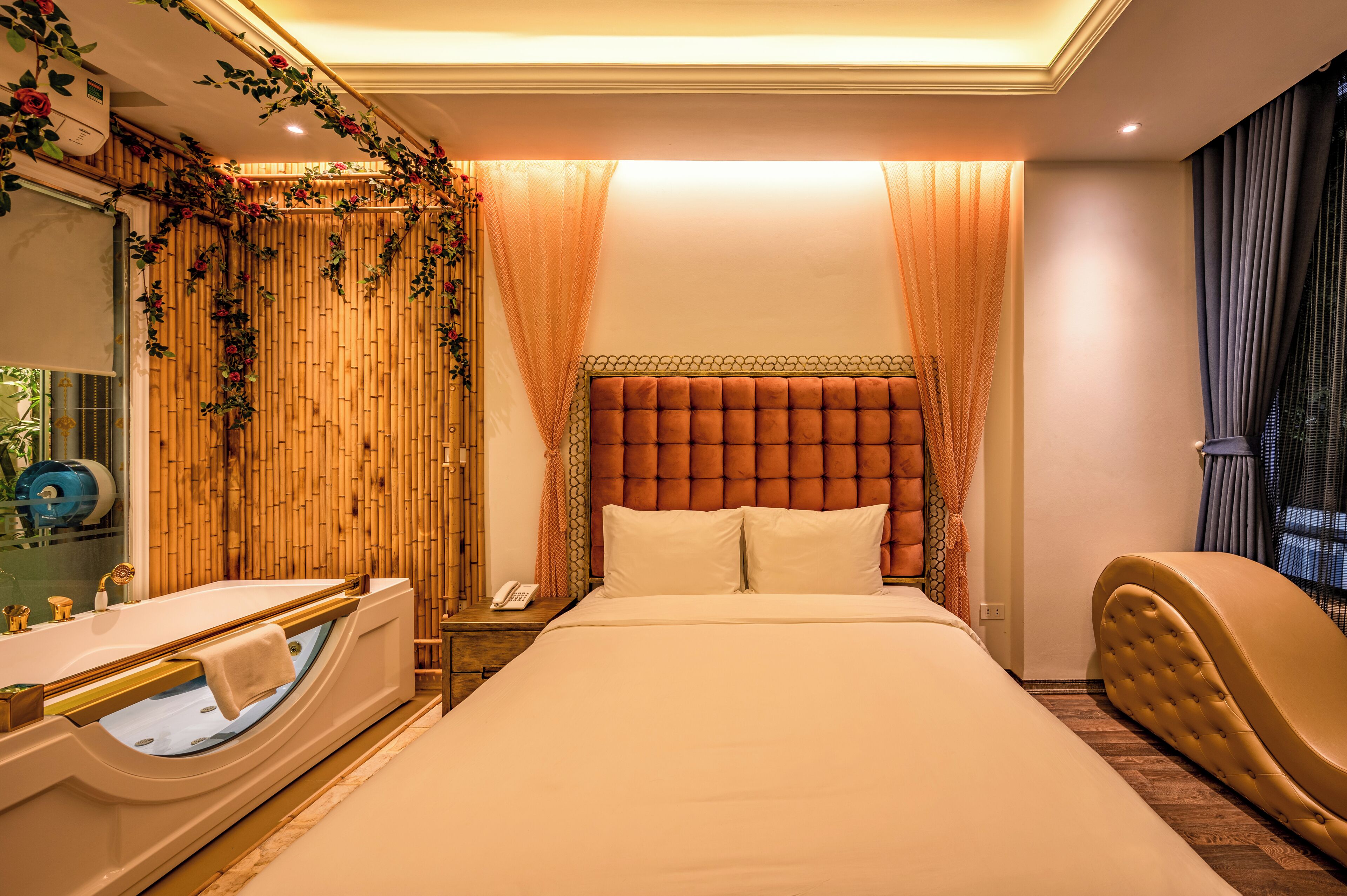 Une chambre d’hôtel avec un grand lit, une baignoire et une coiffeuse avec un miroir.