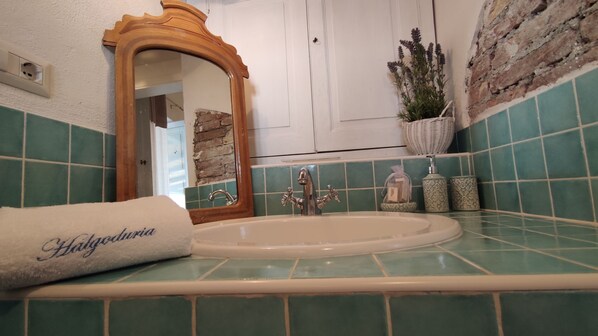 A bathroom with a sink, mirror, and decorative items.
