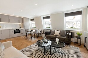 A modern living room with a sofa, coffee table, and dining area.