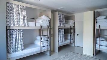A room with bunk beds, each with a patterned curtain.
