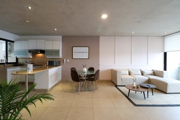 A modern living space with a kitchen, dining area, and seating area. - w* | Picturesque 2BR with Balcony in Miraflores (Miraflores)