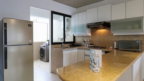 A modern kitchen with white cabinets, a stainless steel refrigerator, a built-in oven, and a microwave. - w* | Picturesque 2BR with Balcony in Miraflores (Miraflores)