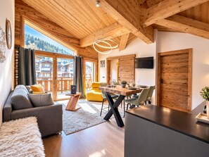 A modern interior with a wooden ceiling, a dining area, and a sofa.