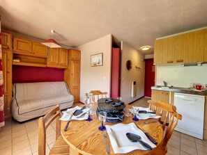 Un espace de vie compact comprenant un coin repas, une kitchenette et un canapé.