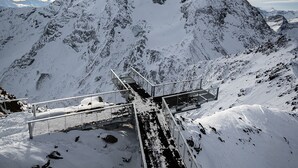 A snow-covered mountain with a metal staircase leading up.